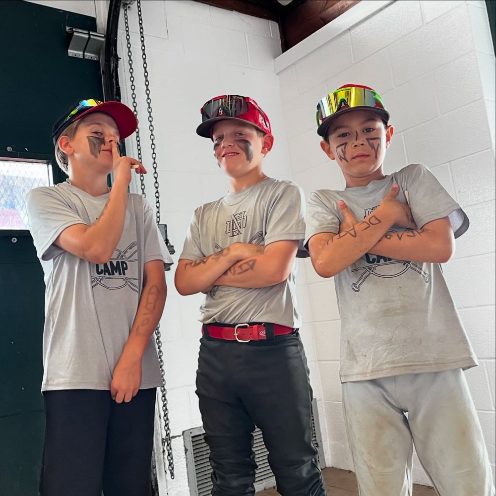 3 boys standing together looking cool in their baseball hats and camp shirts