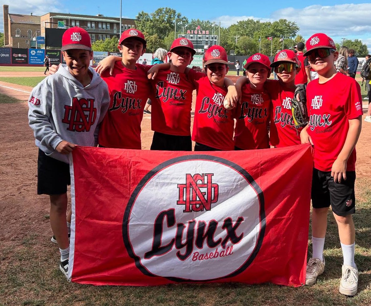 11U Lynx baseball team holding their flag