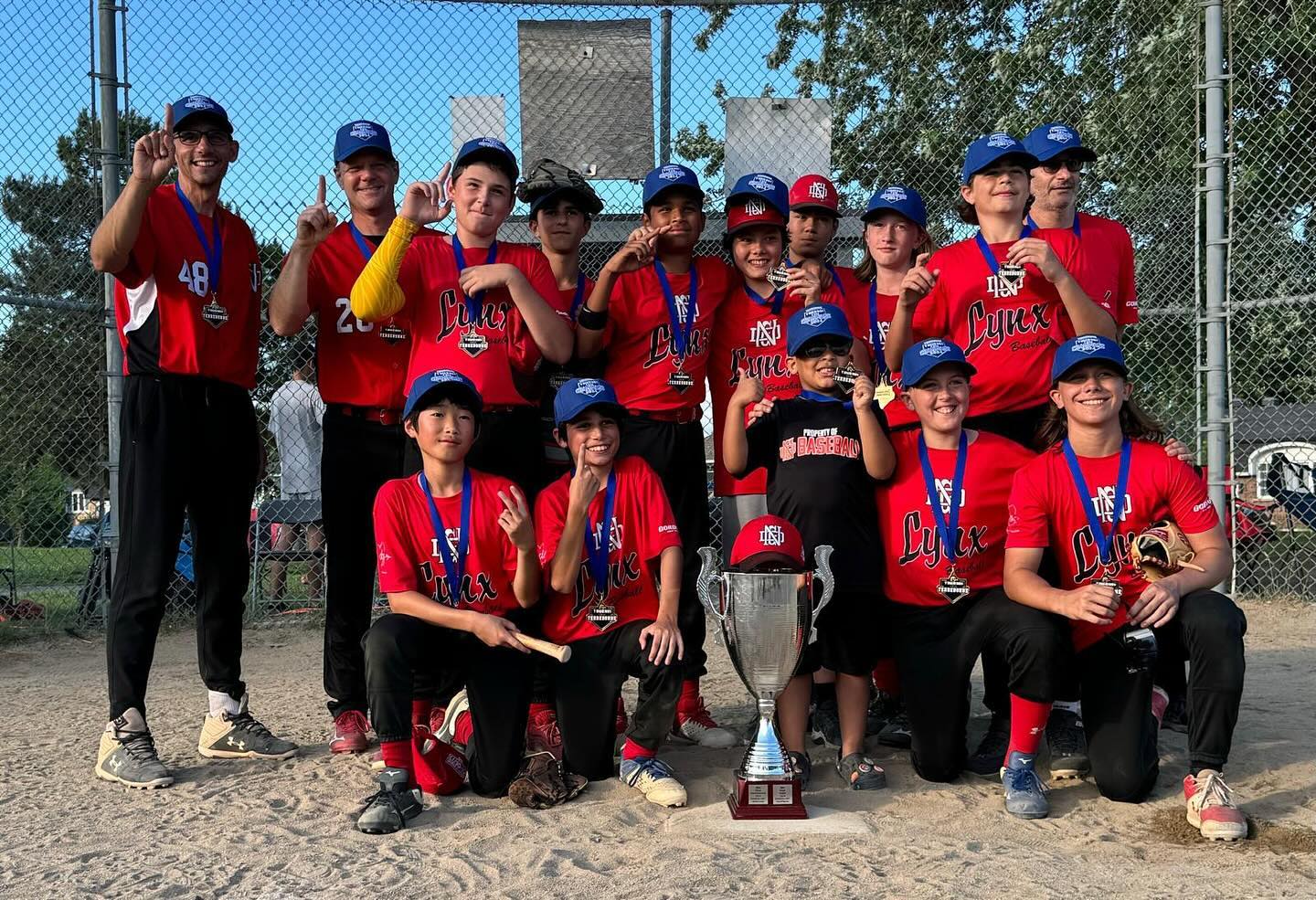 11U Lynx baseball team holding their flag