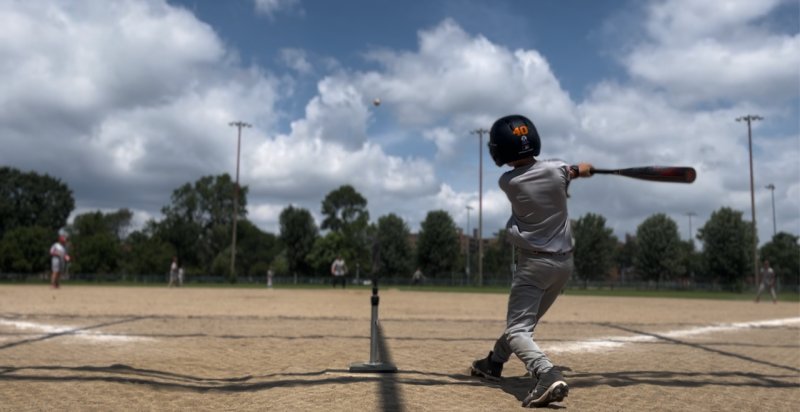 Baseball player hitting the ball off the tee